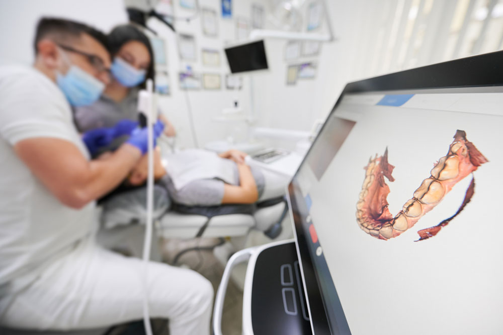 Dentist scanning patient's teeth with modern scanning machine