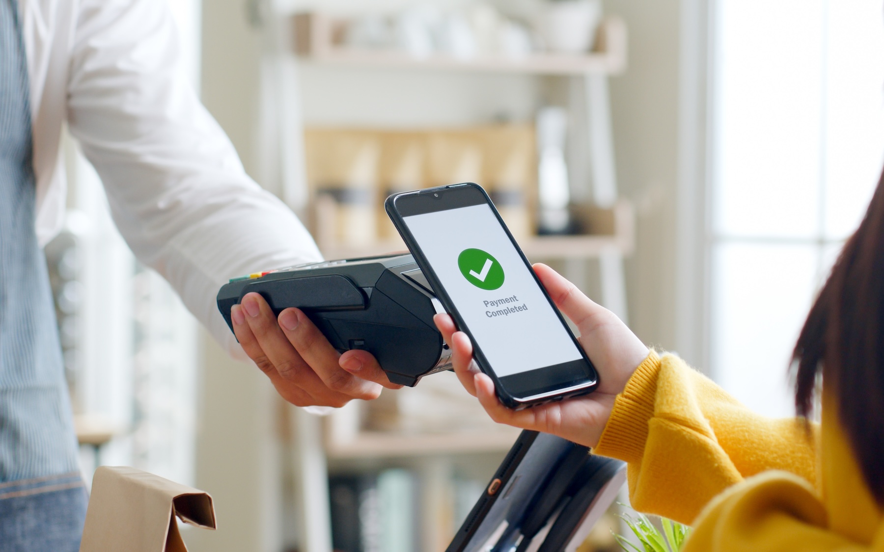Customer using smartphone for NFC payment at cafe restaurant, cashless, contactless technology and money transfer concept