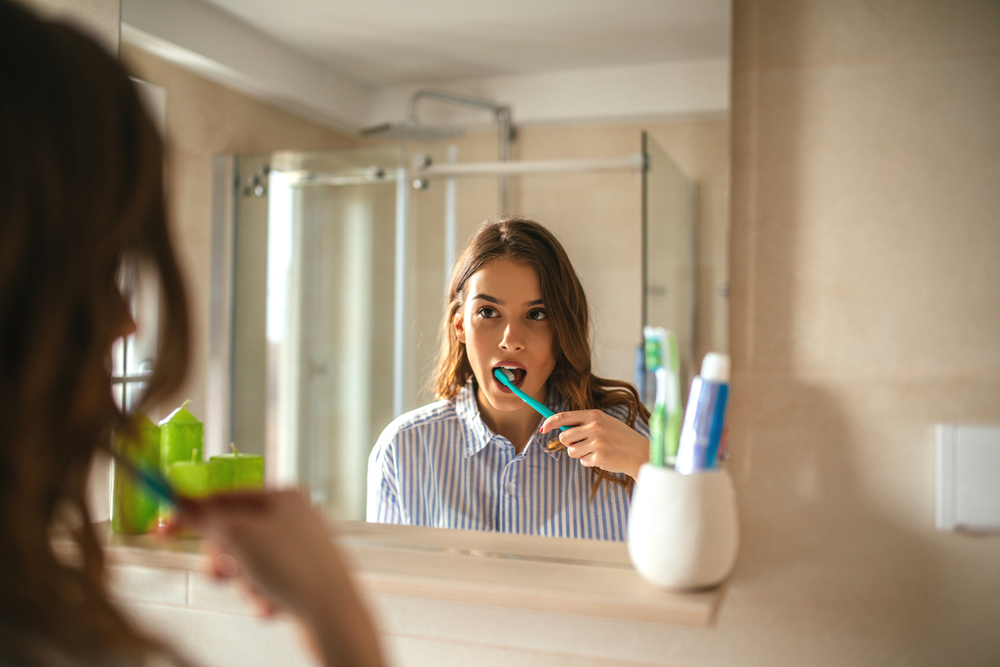 Woman brushing in mirror